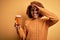 Young beautiful African American afro woman with curly hair drinking glass of beer with happy face smiling doing ok sign with hand