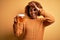 Young beautiful African American afro woman with curly hair drinking jar of beer with happy face smiling doing ok sign with hand