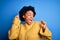 Young beautiful African American afro woman with curly hair wearing yellow casual sweater Dancing happy and cheerful, smiling