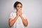 Young beautiful african american girl wearing casual t-shirt standing over white background laughing and embarrassed giggle