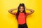 Young beautiful african american woman with hands over head standing over yellow background