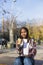 Young beautiful african american woman sitting outdoors in the city with a tablet pc while holding a take away coffee in a sunny