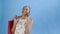 Young beautiful African using phone and holding shopping bags on blue Background in Studio. White dress with flowers