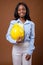 Young beautiful African Zulu businesswoman with hardhat against