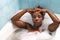 Young and beautiful Afro American woman takes a bubble bath in the bathtub. Beauty and hygiene concept