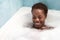 Young and beautiful Afro American woman takes a bubble bath in the bathtub. Beauty and hygiene concept