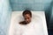 Young and beautiful Afro American woman takes a bubble bath in the bathtub. Beauty and hygiene concept