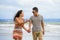 young beautiful and Asian Chinese romantic couple walking together on the beach happy in love enjoying holidays arguing with girl