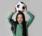 Young beautiful asian girl holding soccer football ball over her head on gray background. Happy Korean soccer player kid