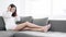 Young beautiful Asian girl using digital tablet and headphone on sofa at home living room, dolly shot