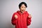 Young beautiful asian girl wearing casual sweatshirt with hoodie over white background celebrating surprised and amazed for