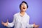 Young beautiful asian scientist girl wearing coat and glasses over purple background crazy and mad shouting and yelling with