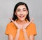 Young beautiful asian woman,long black hair, wore orange t shirt,Showing distrust,suspicious, skeptical, sceptical,Surprise on