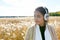 Young beautiful Asian woman thinking and looking away against scenic view of autumn bulrush field
