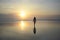 Young beautiful asian woman walking on sand sea shore free and relaxed looking at sun horizon on sunset beach