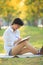 Young beautiful asian woman writing text in diary book in yellow