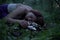 Young Beautiful Attractive woman in Purple Skirt Lay on a stump with white mushrooms at Mysterious Twilight Forest