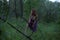 Young Beautiful Attractive woman in Purple Skirt sneaks in the forest at Mysterious Twilight