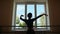 Young beautiful ballerina is dancing on the background of window