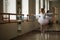 Young beautiful ballerina training near window