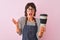 Young beautiful barista woman wearing glasses holding coffee over isolated pink background very happy and excited, winner