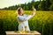 A young beautiful biologist or agronomist examines the quality of rapeseed oil on a rape field. Agribusiness concept