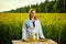 A young beautiful biologist or agronomist examines the quality of rapeseed oil on a rape field. Agribusiness concept