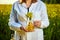 A young beautiful biologist or agronomist examines the quality of rapeseed oil on a rape field. Agribusiness concept