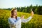 A young beautiful biologist or agronomist examines the quality of rapeseed oil on a rape field. Agribusiness concept