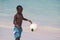 Young beautiful black boy  in blue shorts  playing football on the sunny caribbean beach just after swimming .Bavaro beach,Punta