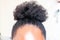 Young beautiful black girl with natural Afro Kinky hair bun. African American Kinky curly woman with cute bun for creative elegant