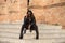 young and beautiful black latin woman wearing black clothes and sunglasses is sitting on the steps of the most important square in