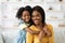 Young Beautiful Black Woman And Her Cute Preteen Daughter Posing At Home
