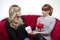 Young beautiful blond and red haired girls giving present box on