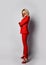 Young beautiful blond woman in stylish elegant sexy deep red official suit, sunglasses and shoes standing and looking at camera