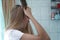 Young beautiful blonde is brushing her hair in the bathroom