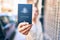 Young beautiful blonde caucasian woman smiling happy outdoors on a sunny day showing Australia passport