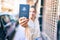 Young beautiful blonde caucasian woman smiling happy outdoors on a sunny day showing Australia passport