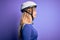 Young beautiful blonde cyclist woman wearing bike security helmet over purple background looking to side, relax profile pose with