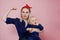 Young beautiful blonde mother with a cute baby. Conceptual gesture to show the biceps