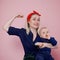 Young beautiful blonde mother with a cute baby. Conceptual gesture to show the biceps
