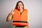 Young beautiful blonde woman with blue eyes wearing orange lifejacket over white background doing happy thumbs up gesture with