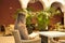 Young and beautiful blonde woman reading a book sitting in the courtyard of a luxurious hotel. Concept books, reading, travel,