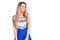 Young beautiful blonde woman wearing cheerleader uniform looking away to side with smile on face, natural expression