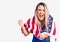 Young beautiful blonde woman wearing cheerleader uniform and united states flag screaming proud, celebrating victory and success