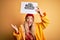 Young beautiful blonde woman wearing raincoat and wool cap holding banner with cloud image very happy and excited, winner