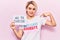 Young beautiful blonde woman wearing t shirt with diversity message holding no to suicide paper pointing finger to one self