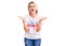 Young beautiful blonde woman wearing t shirt with diversity word message celebrating mad and crazy for success with arms raised