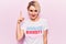 Young beautiful blonde woman wearing t shirt with diversity word message pointing finger up with successful idea