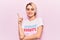 Young beautiful blonde woman wearing t shirt with diversity word message smiling happy pointing with hand and finger to the side
